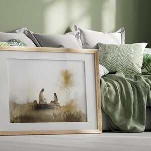 May include: A framed watercolor painting of two figures sitting by a body of water. The figures are silhouetted against a light brown background. The painting is set against a green wall and a bed with pillows and a blanket.