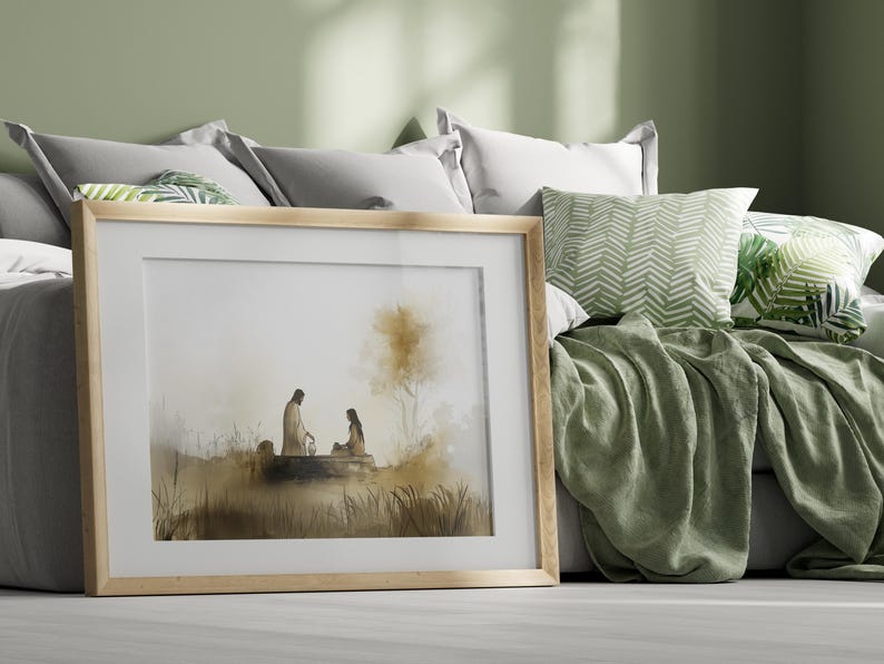 May include: A framed watercolor painting of two figures sitting by a body of water. The figures are silhouetted against a light brown background. The painting is set against a green wall and a bed with pillows and a blanket.