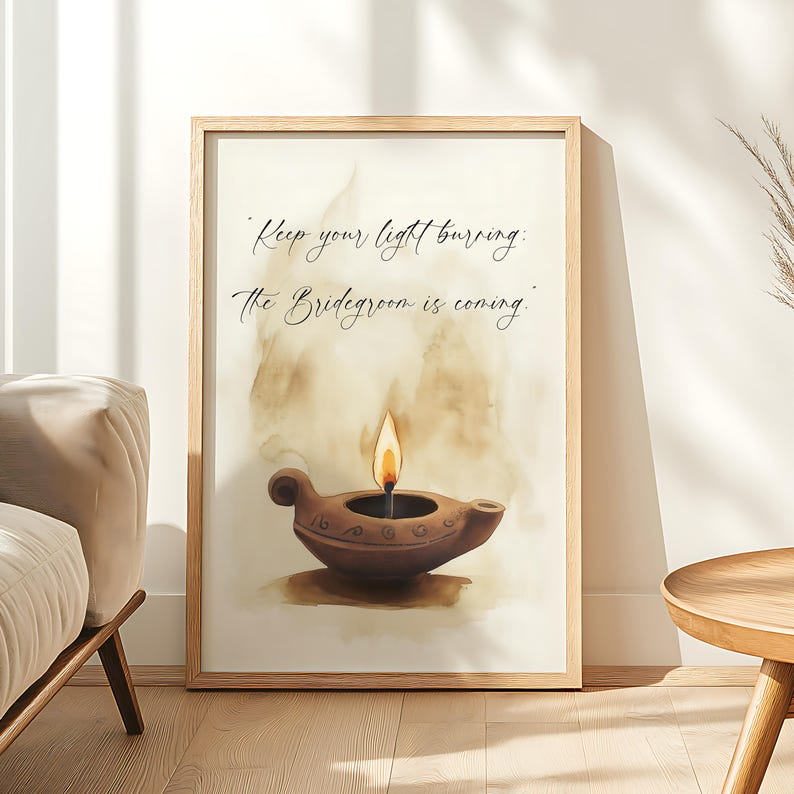 May include: A framed print featuring a watercolor illustration of a brown oil lamp with a lit flame. The artwork includes the text "Keep your light burning: The Bridegroom is coming" in elegant script. The frame is a light wood color.