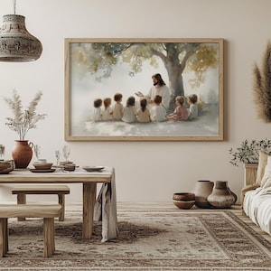 Pu&ograve; includere: Un dipinto ad acquerello di Ges&ugrave; che insegna a un gruppo di bambini sotto un albero. Il dipinto &egrave; incorniciato in una cornice di legno chiaro e appeso a una parete bianca.