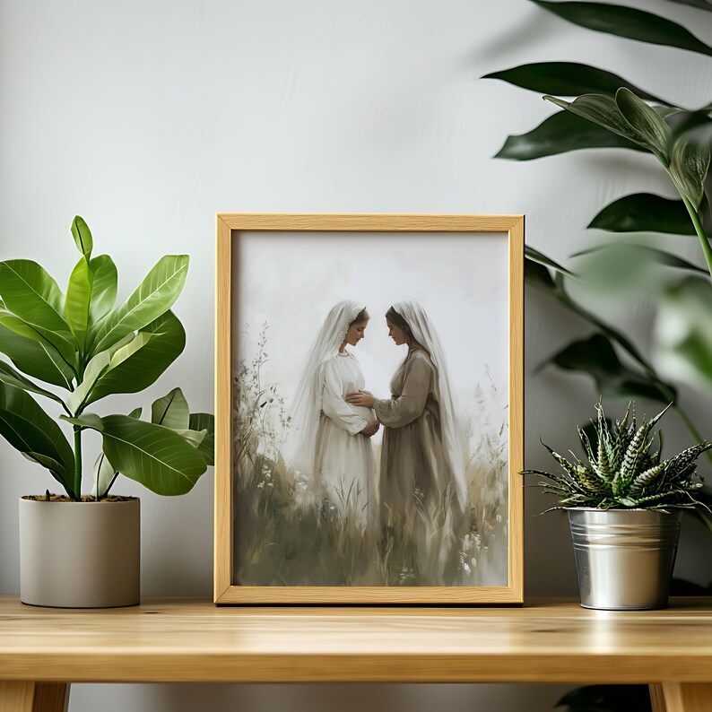 May include: A framed painting depicting two women in long white and brown dresses, standing in a field of tall grass. The women are facing each other and holding hands. The painting is in a light brown frame.