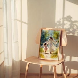 May include: A framed print showing a figure in white robes and a young girl in a pink dress, walking in a green landscape. The artwork is displayed on a wooden chair, with soft lighting. The image has a warm, inviting feel.