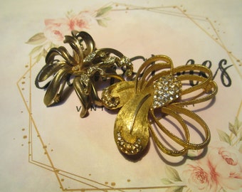 Two vintage BSK gold toned floral brooches with rhinestones.