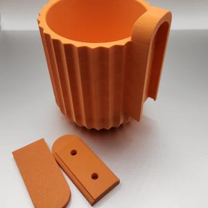 May include: Orange plastic cup holder with a handle and two orange plastic mounting brackets.