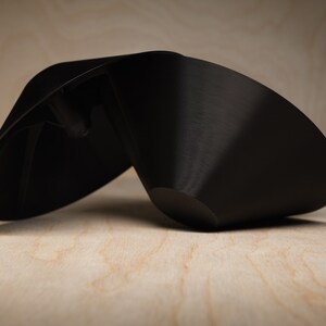 May include: A black, cone-shaped ceramic planter with a wide opening and a smooth, matte finish.