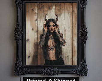 Puede incluir: Una impresión enmarcada que presenta a una persona con cabello largo y negro, tatuajes y cuernos. La persona está frente a un fondo de madera. El marco negro tiene detalles ornamentados. El texto "Printed & Shipped" está en la parte inferior del marco.