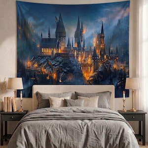 May include: A large rectangular wall tapestry featuring a detailed illustration of a sprawling stone castle perched on a rocky cliffside at night. The scene is illuminated by warm golden lights from windows and torches against a dark blue sky.