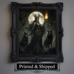 Puede incluir: Una impresión enmarcada que presenta una escena de fantasía con una mujer con un vestido oscuro sosteniendo una llama, rodeada de lobos y cuervos, sobre una luna llena. El marco es adornado y negro. El texto "Printed & Shipped" está en la parte inferior.