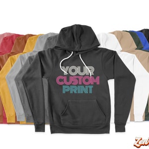 May include: A variety of colors of hooded sweatshirts with the text "YOUR CUSTOM PRINT" in a retro font on the front of the black sweatshirt.