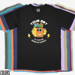 May include: Black t-shirt featuring a graphic of a robot with flowers on its head. The text "YOUR ART" is above the robot and "FULL COLOR LOGOS GRAPHICS ART OR PHOTOS" is below the robot.