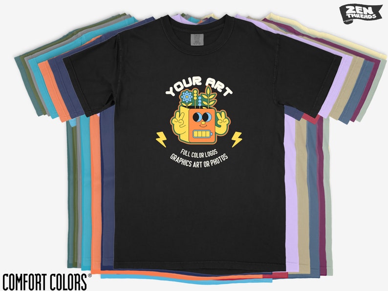 May include: Black t-shirt featuring a graphic of a robot with flowers on its head. The text "YOUR ART" is above the robot and "FULL COLOR LOGOS GRAPHICS ART OR PHOTOS" is below the robot.