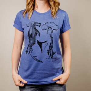 May include: A royal blue t-shirt with a black and white graphic print of hammerhead sharks and a shark tooth.