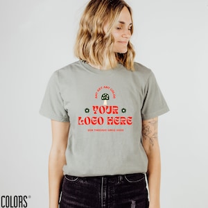 May include: A light green t-shirt with a mushroom graphic and the text "ANY ART ANY COLOR * YOUR LOGO HERE * ZEN THREADS SINCE 2000".