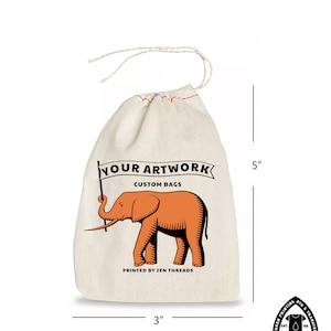 Op de afbeelding: Een witte katoenen trekkoordtas met een rode olifant-illustratie en de tekst "YOUR ARTWORK CUSTOM BAGS PRINTED BY ZEN THREADS". De tas is 12,7 cm hoog en 7,6 cm breed.
