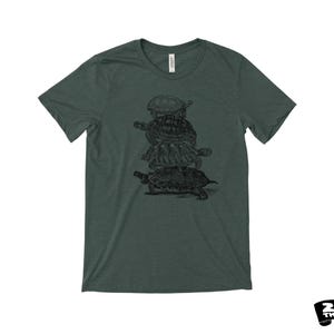 May include: Dark green t-shirt with a black illustration of four turtles stacked. The shirt has a crew neck and short sleeves. The brand "ZEN THREADS" is printed in black on a white background.