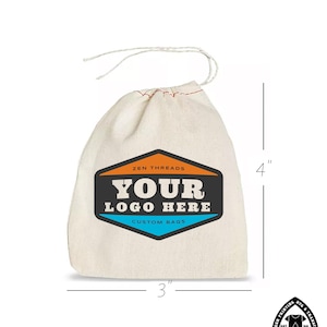 Op de afbeelding: Een witte katoenen trekkoordtas met een zwart en oranje logo met de tekst "Zen Threads" en "Your Logo Here" met daaronder de tekst "Custom Bags". De tas is 4 inch hoog en 3 inch breed.