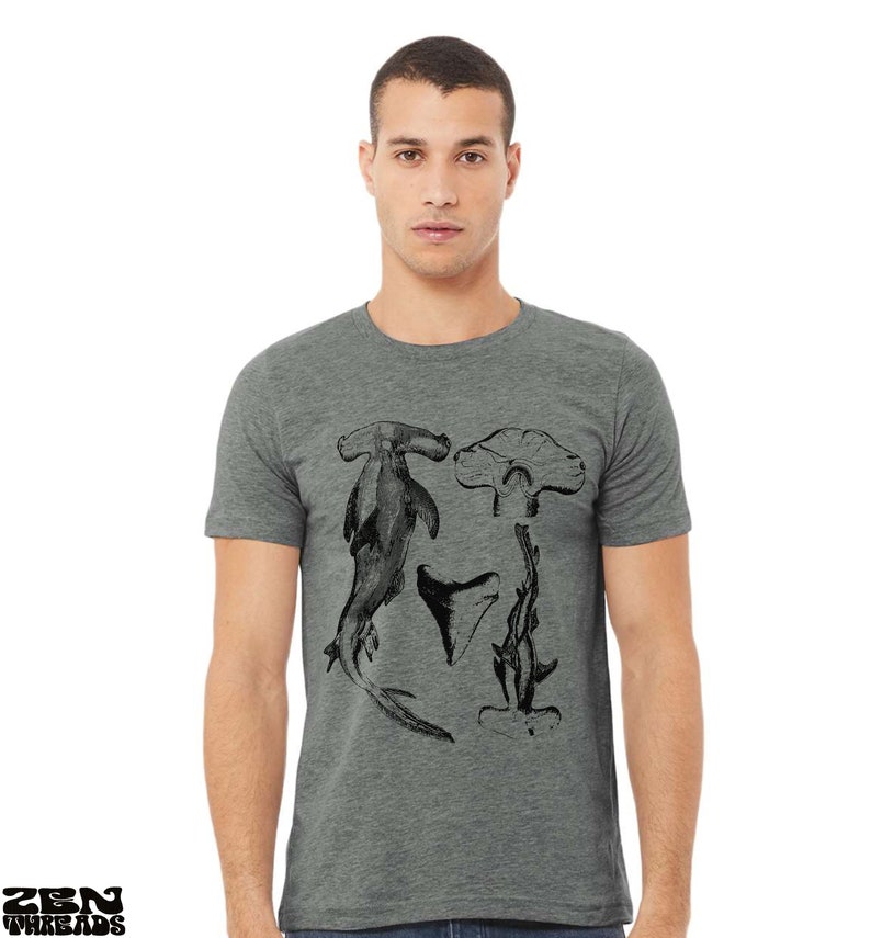 May include: A heather grey t-shirt with a black and white graphic print of hammerhead sharks.
