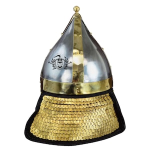 May include: A silver and brass helmet with a pointed top and a gold chainmail neck guard. The helmet has a decorative design on the front.
