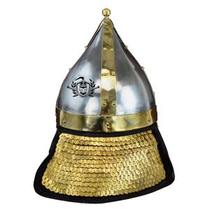 May include: A silver and brass helmet with a pointed top and a gold chainmail neck guard. The helmet has a decorative design on the front.