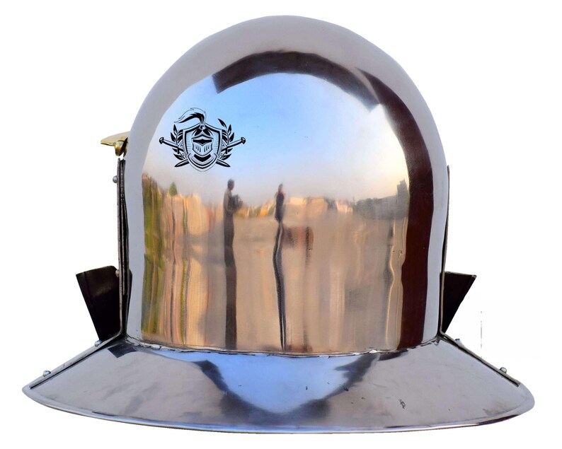 Pode incluir: Um capacete prateado com uma aba larga e uma crista no topo. O capacete &eacute; feito de metal e tem um acabamento brilhante.