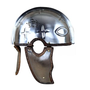 May include: A polished silver Roman helmet with a brown leather trim and cheek guards. The helmet features decorative cross and eye-shaped cutouts, and a crest emblem. The design is reminiscent of ancient Roman military headwear.
