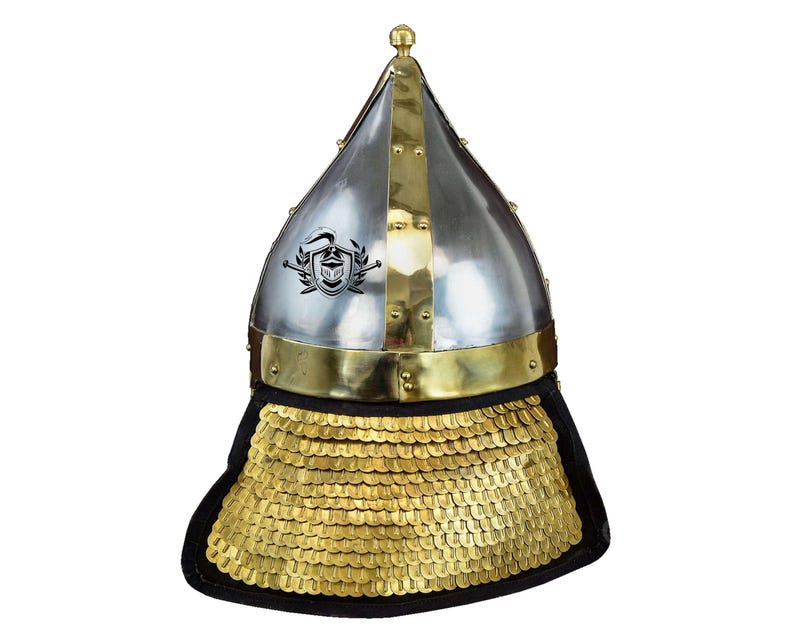 May include: A silver and brass helmet with a pointed top and a gold chainmail neck guard. The helmet has a decorative design on the front.