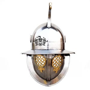 May include: A silver Roman gladiator helmet with a brass grill over the eyes and a crest on top. The helmet has a decorative design on the front.