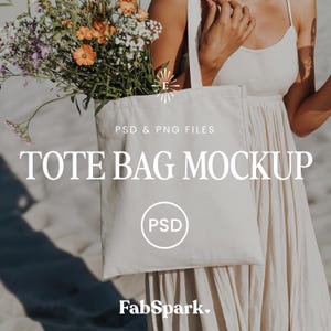 Może przedstawiać: Kremowy mockup torby typu tote z tekstem "TOTE BAG MOCKUP" i "PSD & PNG FILES". Torba jest trzymana przez osobę w kremowej sukience i wypełniona bukietem kwiatów. Logo FabSpark znajduje się na dole.
