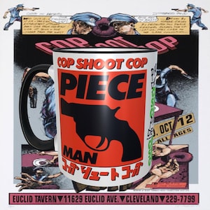May include: White ceramic mug with a black handle. The mug has a red and black graphic of a gun with the text "COP SHOOT COP PIECE MAN" in black and white. The text "バリュートコンプ" is in Japanese characters.