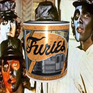 May include: White ceramic mug with a black rim and handle. The mug features a vintage-style graphic of a subway train with the text "Furies 1979 Riverside, Manhattan" and "Staub Baths".
