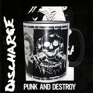 May include: Black and white mug with a skull graphic and the text "DISCHARGE" on the front. The text "STAND UP FIGHT FOR YOUR RIGHTS" is printed on the top of the mug. The mug is on a black background with the text "PUNK AND DESTROY" printed below.