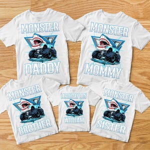 K&ouml;nnte beinhalten: F&uuml;nf wei&szlig;e T-Shirts mit einem blauen Hai-Monstertruck-Motiv. Die Shirts zeigen die Aufschriften "Monster Daddy", "Monster Mommy", "Monster Brother", "Birthday Boy William" und "Monster Sister".