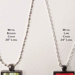 May include: Two silver chains with pendants. The chain on the left is a 20-inch metal beaded chain. The chain on the right is a 24-inch metal link chain.
