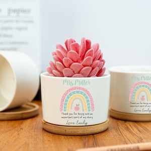 May include: White ceramic planter with a pink succulent, featuring a rainbow design and the text "Mrs. Miller". The planter includes the message "Thank you for being such an important part of my story, Love Emily".