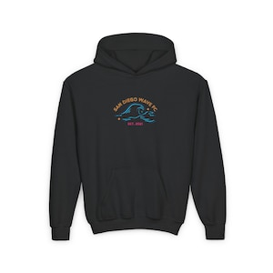 May include: Black hooded sweatshirt with a front pocket. The front displays a logo with the text "SAN DIEGO WAVE FC" above a wave design in orange and blue, with "EST. 2021" below. The hoodie is made of a soft material.