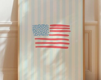 May include: A framed print featuring a stylized American flag. The flag design includes a blue field with white stars and red stripes. The background has vertical stripes in light blue and cream colors. The frame is made of wood.