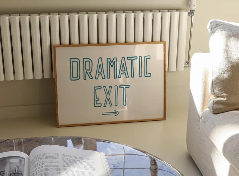 May include: A framed print with a white background and a teal blue outline of the text "Dramatic Exit" with an arrow pointing to the right.