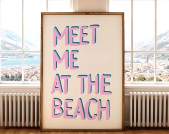 May include: A white poster with the text "MEET ME AT THE BEACH" in pink and blue letters. The poster is framed in a light wood frame.