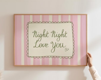 May include: A framed print with a light pink and white striped background. The print features the words "Night Night Love You" in a whimsical script within a scalloped border. A small heart is included.
