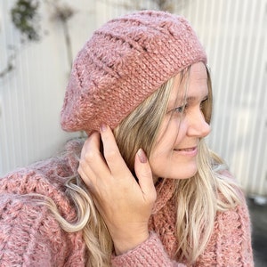 Peut inclure: Un béret en tricot rose avec un motif texturé. Le béret est porté par une personne aux cheveux blonds.