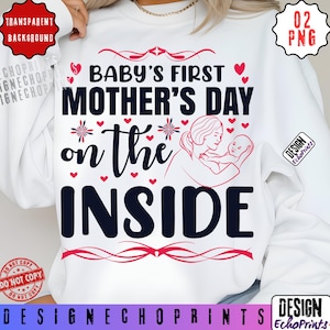 Può includere: Felpa bianca con la scritta "Baby's First Mother's Day on the Inside". Il design include cuori, elementi floreali e un'illustrazione di una madre con il suo bambino. Il testo è in nero e rosso.