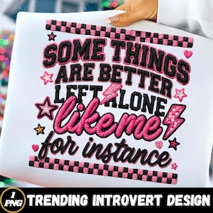 Puede incluir: Camiseta blanca con la frase bordada "SOME THINGS ARE BETTER LEFT ALONE like me for instance." El diseño incluye detalles en rosa y negro, estrellas y rayos. La parte inferior de la camiseta tiene el texto "TRENDING INTROVERT DESIGN".