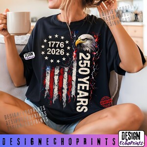 Puede incluir: Camiseta negra con un dise&ntilde;o desgastado de la bandera estadounidense, el texto "1776 2026" y "250 YEARS". El dise&ntilde;o incluye una cabeza de &aacute;guila y rayos. La camiseta tiene cuello redondo y mangas cortas.