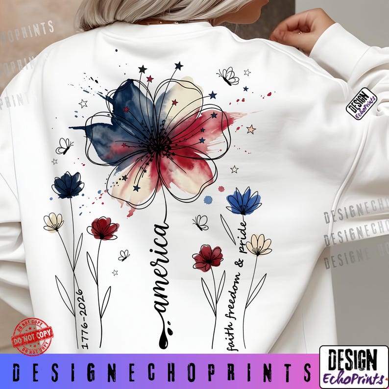 K&ouml;nnte beinhalten: Wei&szlig;es Sweatshirt mit einem patriotischen Blumendesign in Rot, Wei&szlig; und Blau. Das Wort "america" ist in Schreibschrift geschrieben, mit zus&auml;tzlichen floralen Elementen und dem Text "faith freedom & pride". Das Design enth&auml;lt auch Sterne und Schmetterlinge.