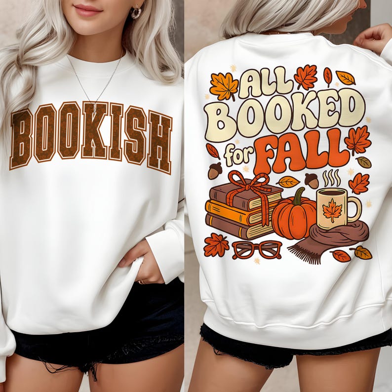 Puede incluir: Sudadera blanca con la palabra "BOOKISH" en letras marrones en la parte delantera. La parte trasera presenta un gr&aacute;fico con tem&aacute;tica oto&ntilde;al con el texto "ALL BOOKED for FALL", calabazas, libros y hojas.