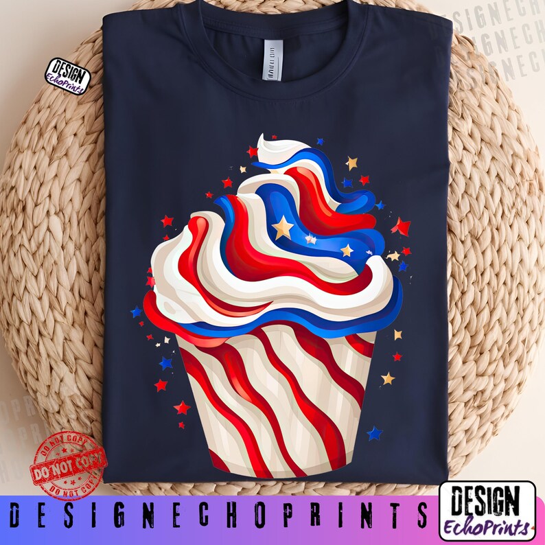 Puede incluir: Camiseta azul marino con un dise&ntilde;o de cupcake con glaseado rojo, blanco y azul y detalles de estrellas. La magdalena tiene papel a rayas rojas y blancas. El texto "DESIGNECHOPRINTS" est&aacute; en la parte inferior.
