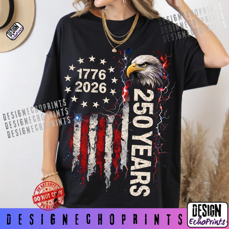 Puede incluir: Camiseta negra con un dise&ntilde;o desgastado de la bandera estadounidense, el texto "1776 2026" y "250 YEARS". El dise&ntilde;o incluye una cabeza de &aacute;guila calva y rayos. La camiseta tiene cuello redondo y mangas cortas.