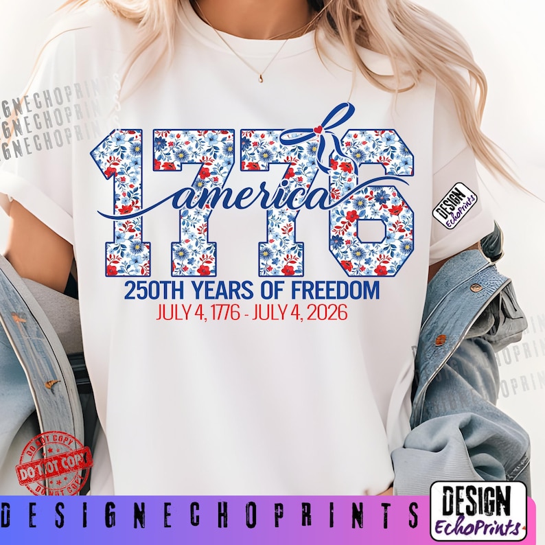 Puede incluir: Camiseta blanca con el texto "1776 america" en un dise&ntilde;o floral con flores rojas, blancas y azules. La camiseta tambi&eacute;n incluye el texto "250TH YEARS OF FREEDOM JULY 4, 1776 - JULY 4, 2026".