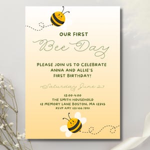 May include: A birthday invitation with a yellow and white gradient background. The text reads "OUR FIRST Bee Day" with details about the event, including the date, time, and location. The invitation is decorated with cartoon bees.