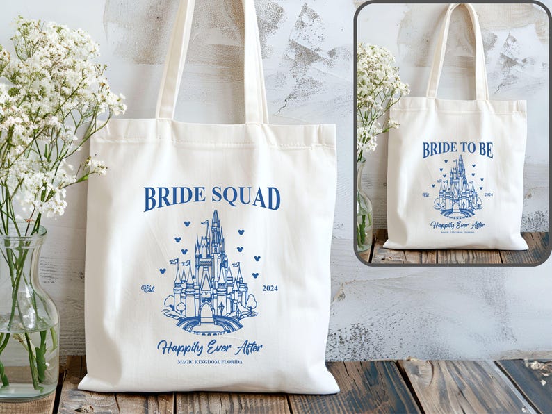 May include: Two white canvas tote bags with blue text and a blue illustration of Cinderella's castle. The bag on the left says "Bride Squad" and the bag on the right says "Bride to Be". Both bags say "Happily Ever After" and "Magic Kingdom, Florida".